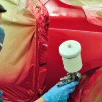 Worker painting a car.