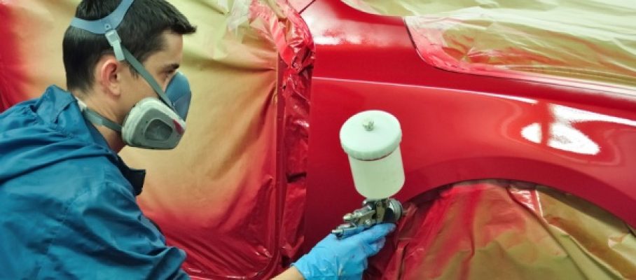 Worker painting a car.